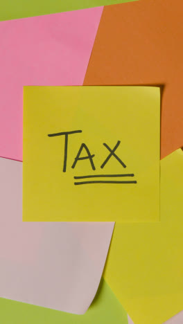 Vertical-Video-Business-Concept-Of-Revolving-Sticky-Notes-With-Tax-Written-On-Top-Note